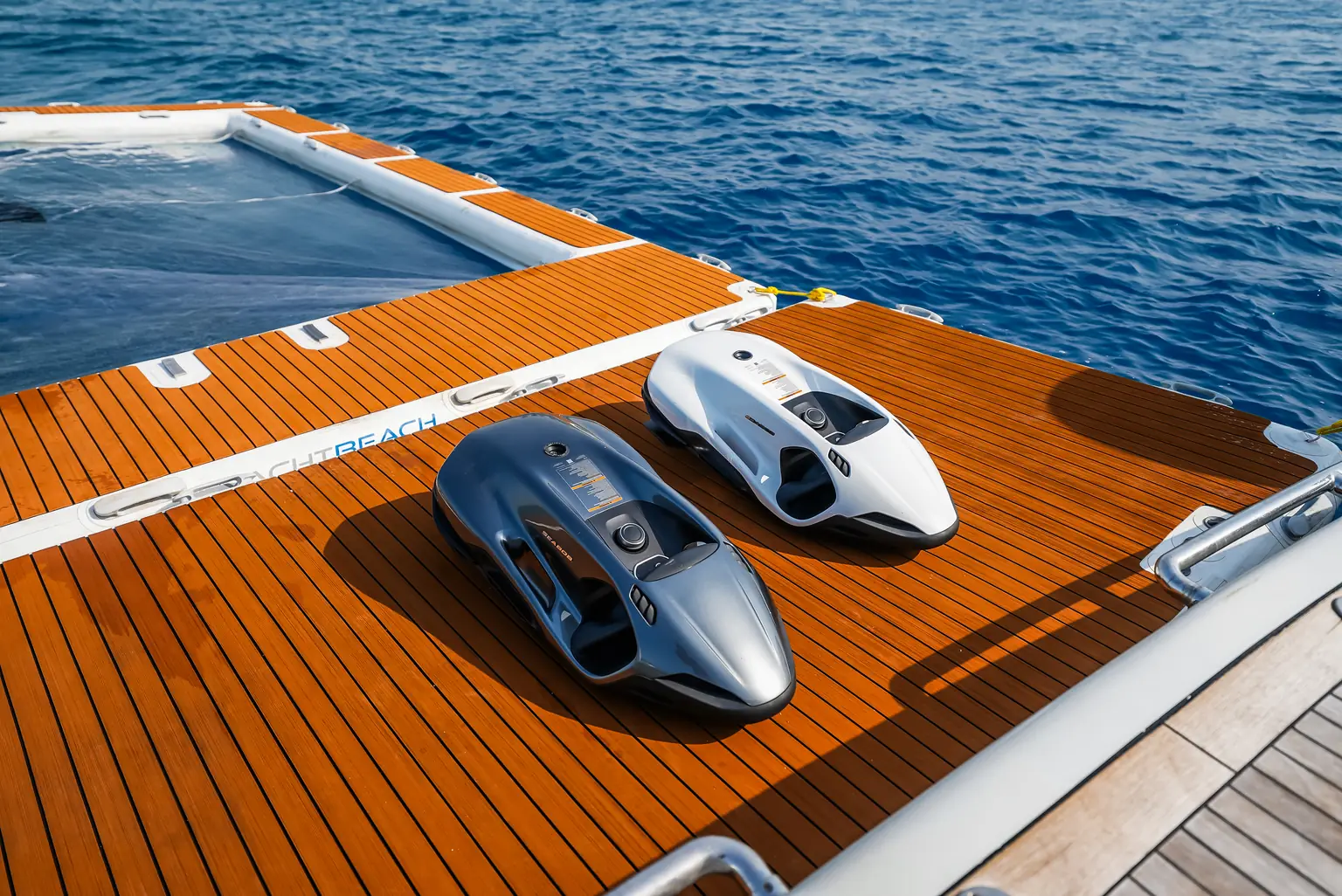 Two powered water toys stowed on the teak bathing platform