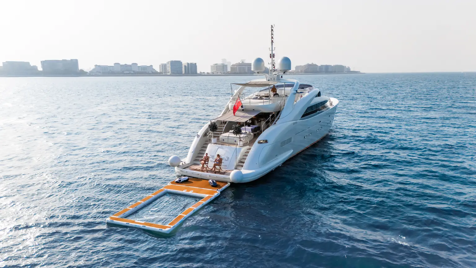 Bow quarter view of the yacht with the floating sea pool deployed off her stern