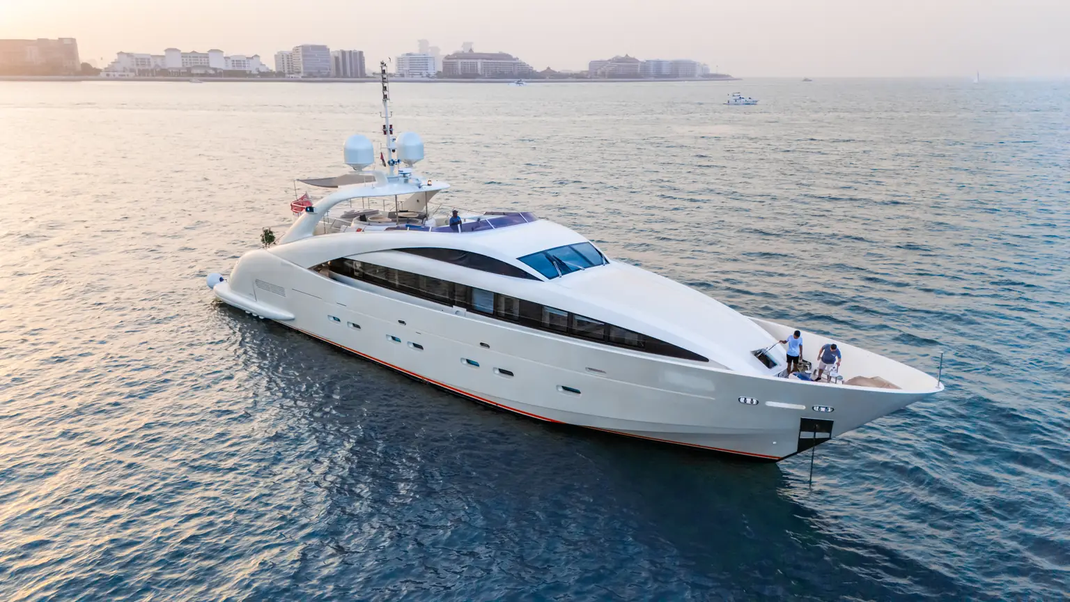 Plan B of Freedom under way with the Dubai coastline and high-rise skyline behind her