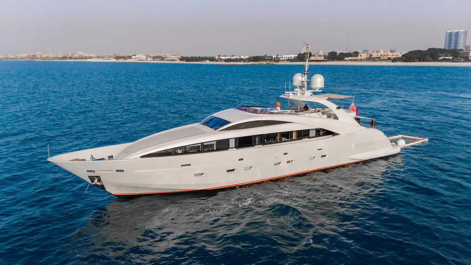 Port side profile of Plan B of Freedom with the Dubai shoreline behind her