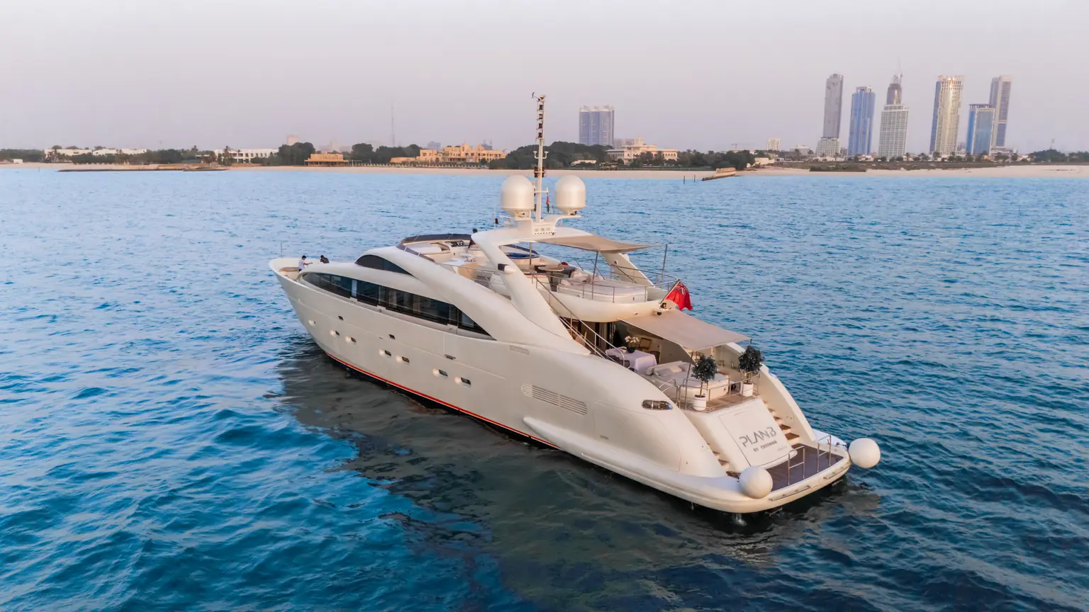 Plan B of Freedom at anchor with the towers of the Dubai skyline behind her