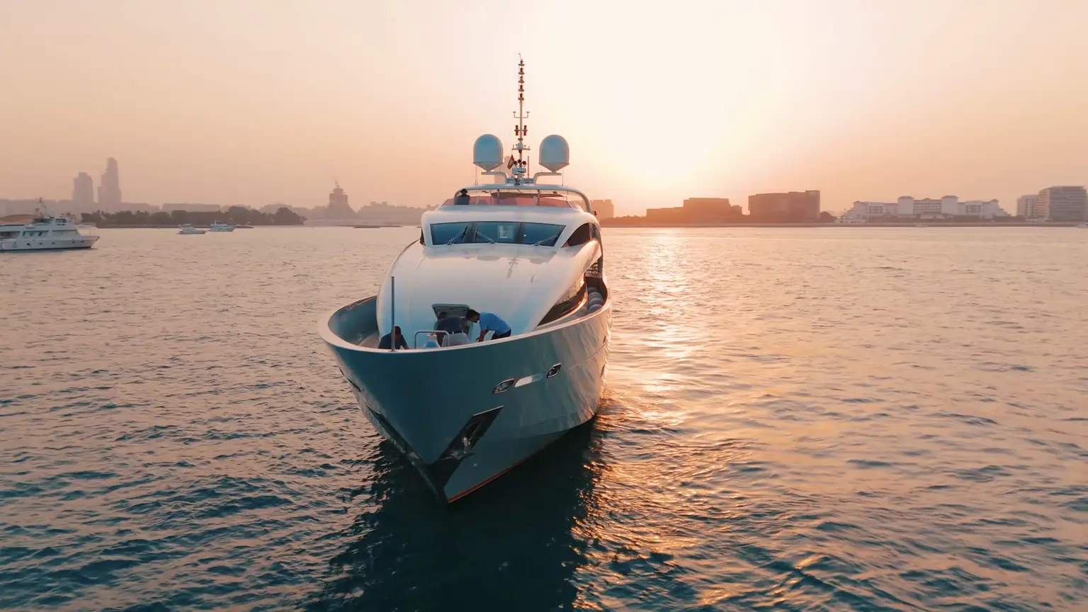 Plan B of Freedom under way off Dubai at sunset, seen head on from the water