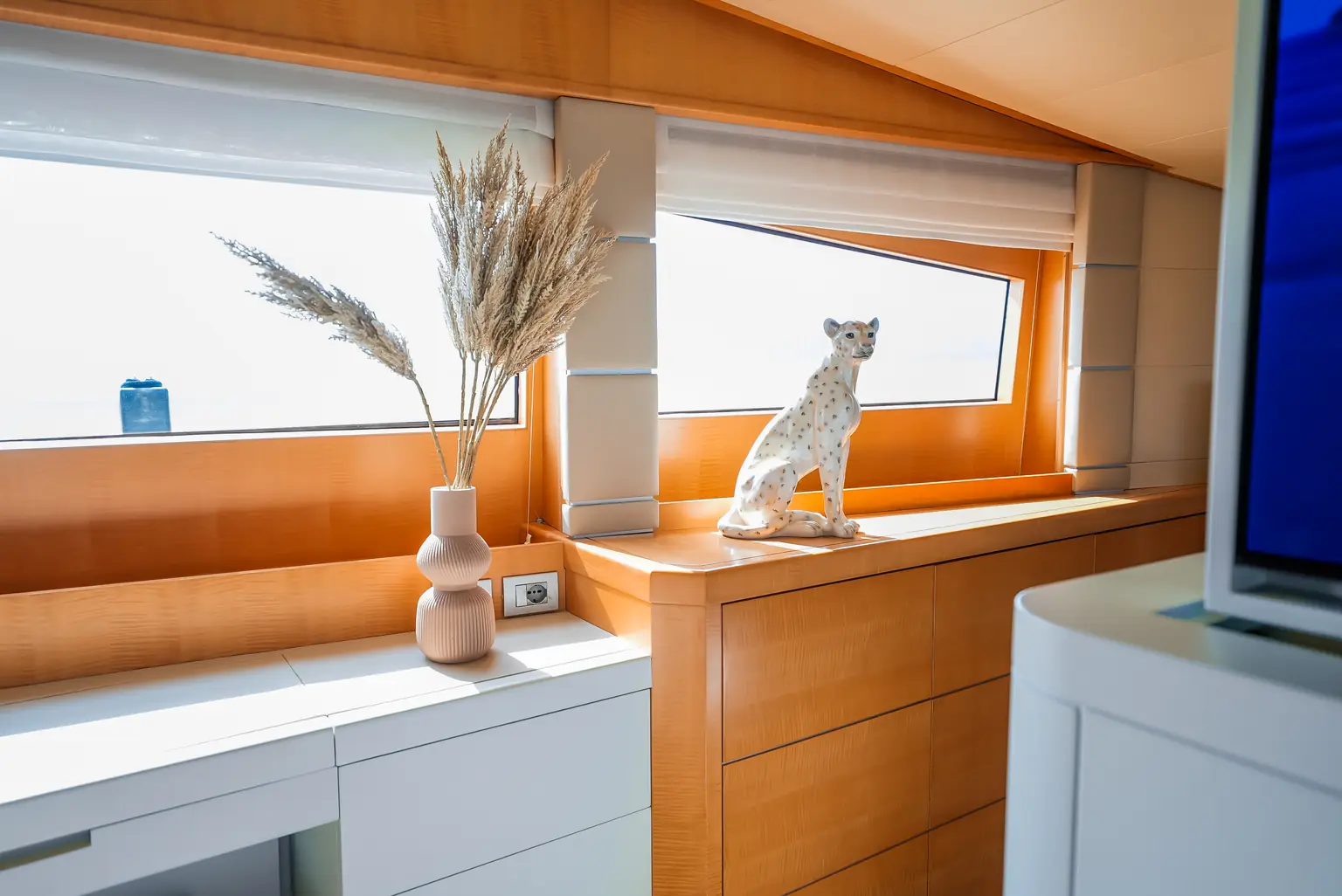 Cabin console with a dried flower arrangement and an ornament beside the window